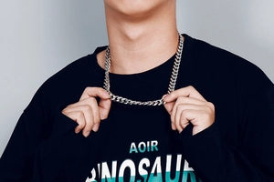 Detail of a silver Cuban link chain necklace worn by a model to show texture and length