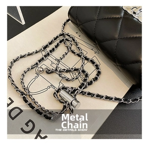Detail of quilted black leather bag with silver chain strap and adjustable ball lock