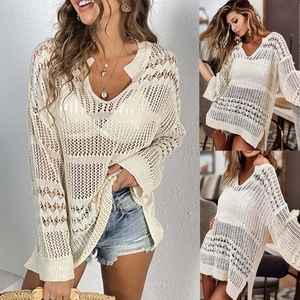 Detalle de blusa de playa de punto blanco con intrincados patrones de ganchillo calado