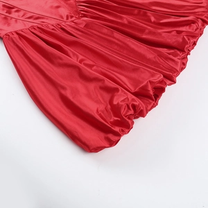Detail of red satin fabric with elegant pleated texture and draped fold design