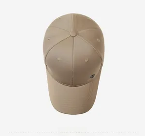 Top down view of khaki cotton baseball cap with six-panel design and metal logo badge detail