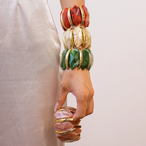 Gros plan de bracelets géométriques en acrylique marbré avec anneaux dorés