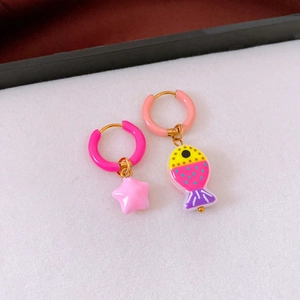 Detail of asymmetric summer earrings featuring a pink star and colorful enamel fish charm