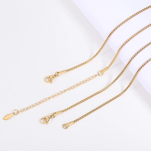 Close-up of golden stainless steel box chain with lobster clasp and extender