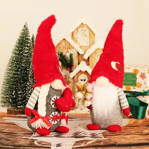 Pair of Christmas gnomes with red hats and hearts for festive home table decoration