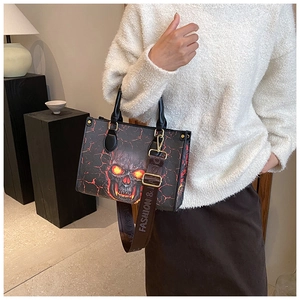 Detail of fashion tote bag with flame skull print and wide branded shoulder strap