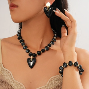 Close-up of black marble acrylic heart pendant necklace with golden metal accents