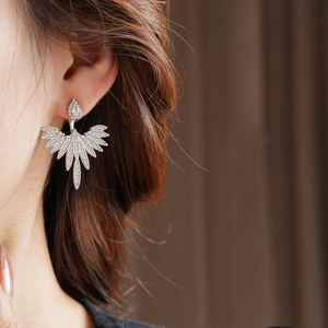 Close-up of elegant leaf shaped silver earrings with shimmering zircon stones on model