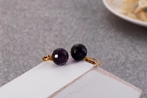 Detail of faceted purple crystal ball earrings with elegant gold stainless steel hooks
