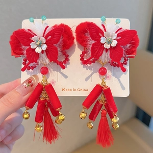 Detail of red Chinese style hair clips with butterfly design, white fur, and tassels