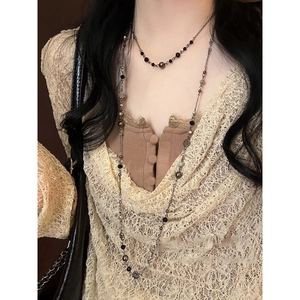 Detailed view of multilayered crystal floral beads and metallic chain on a model