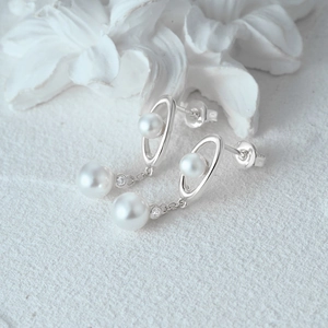 Macro view of S925 silver pearl drop earrings with glossy finish and zircon details