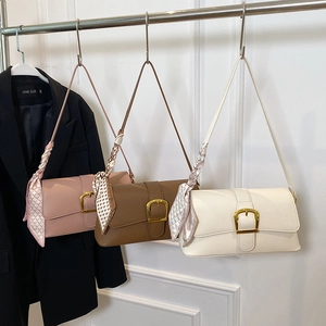 Three leather baguette bags in pink, brown and beige with gold buckles and silk scarves