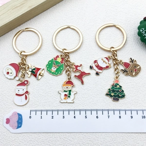 Detail view of colorful enamel Christmas keychains with dimensions shown on a ruler scale