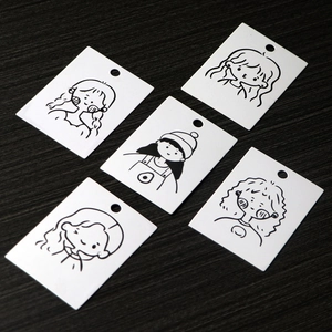Detail of five white earring display cards with minimalist black line art faces