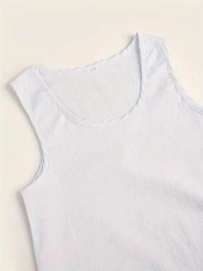 Gros plan du haut blanc sans manches montrant la texture plissée et le col rond