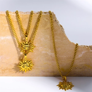 Vintage sun face pendant necklaces with Cuban chains displayed on a stone pedestal