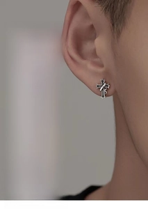 Macro shot of 925 sterling silver cross stud earring with gothic vintage textures
