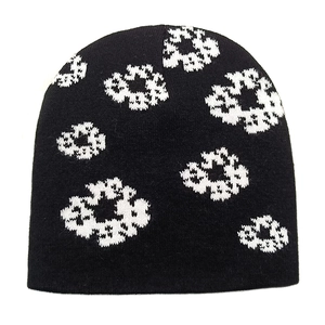 Close-up of the knitted texture and white jacquard floral pattern on a black beanie