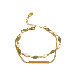 Double-layered vintage gold bracelet with green and white beads in a geometric design
