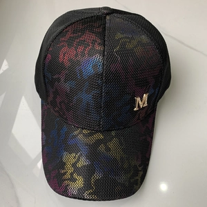 Close-up of breathable black mesh cap with vibrant tie-dye pattern and golden metal M logo