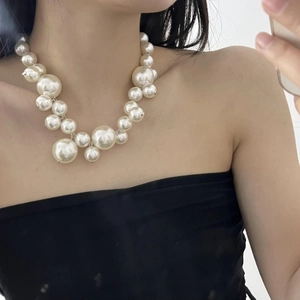 Detail of multi-size pearl strand necklace showing bubbly layered texture and retro style
