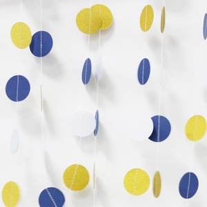 Detail of glitter gold and blue circle paper garlands with fine white stitching for parties