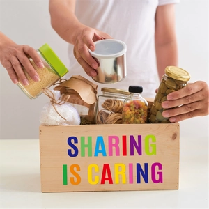 Close-up of wooden crate with vinyl stickers and food jars for sharing and caring