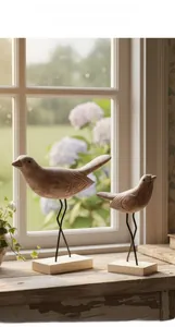 Detailed close-up of two handcrafted wooden bird sculptures with vintage carved texture