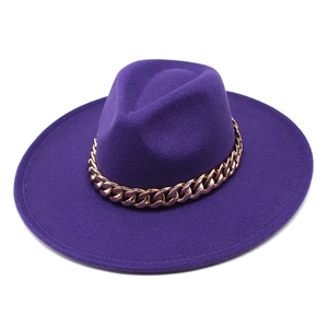 Detailed view of dark purple wide brim fedora with thick gold metal Cuban chain decoration