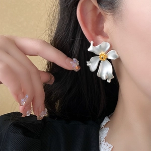 Close-up of a large silver flower earring featuring artistic French vintage design