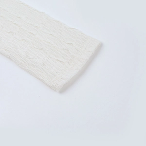 Gros plan sur la texture du tricot blanc montrant des motifs côtelés et fibres douces