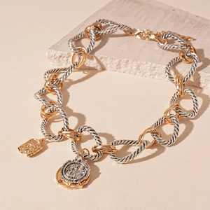 Collana vintage bicolore con catena a spirale, pendente a moneta e rilievo geometrico