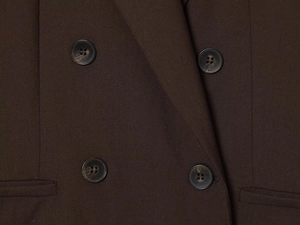 Detail of dark brown blazer featuring tortoiseshell textured buttons and premium wool fabric