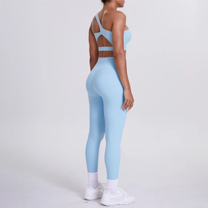 Detail view of light blue one-shoulder sports bra and high-waisted yoga pants fitness set
