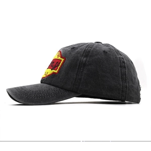 Détail d'une casquette de baseball noire délavée avec broderie rouge et jaune