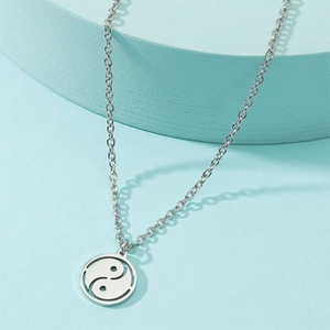 Detail of silver stainless steel Tai Chi Yin Yang pendant with compass feather accents