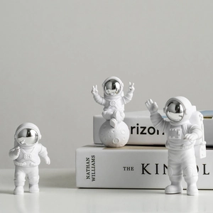Detailed trio of white astronaut figurines in different poses with silver visor accents