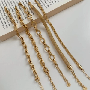 Collection of five golden stainless steel chains in various trendy industrial link designs