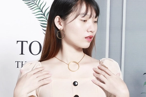 Golden hollow geometric circular necklace and earrings jewelry set worn by a model