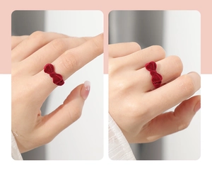 Detail of red velvet strawberry ring box with bowknot worn on finger from different angles