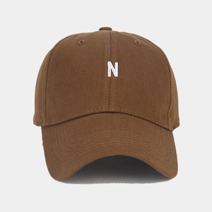 Brown cotton baseball cap with white N letter embroidery and curved brim in retro style