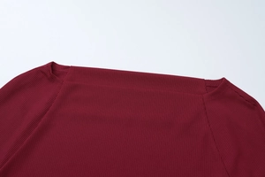 Dettaglio del top a maniche lunghe in maglia a coste bordeaux con cuciture sul collo