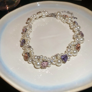 Detail of beaded necklace with faux pearls and colorful heart-shaped rhinestones