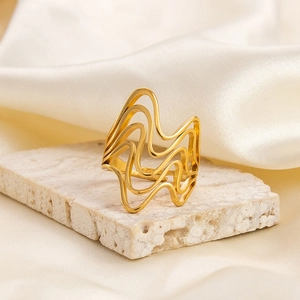 Close-up of irregular 18K gold-plated stainless steel ring on elegant stone background