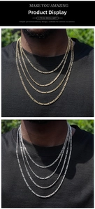 Detail of layered 3mm Figaro and NK stainless steel chains in gold and silver on male model