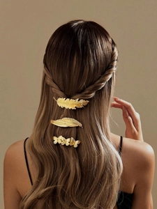 Three-piece gold metal hair clips with leaf and butterfly shapes on a woman's hair