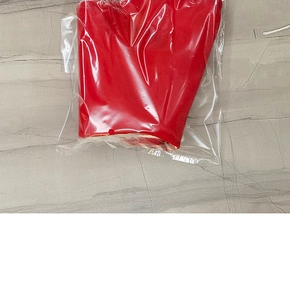 Close-up of red Christmas gnome textile gift bag packaged in a clear protective plastic bag