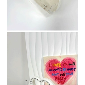 Detail of white acrylic marble handbag featuring heart handle and silver beaded edge