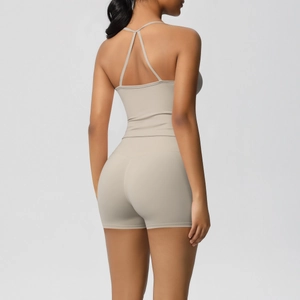 Detail of cross back Y-shape straps and high waist shorts on a beige yoga set